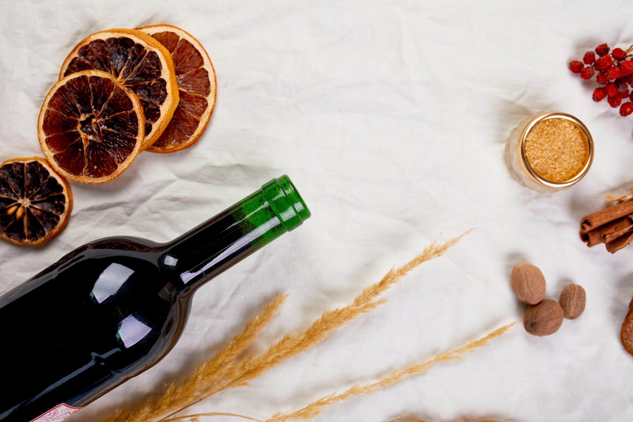 Flat lay of ingredients and bottle of red wine for winter seasonal mulled wine